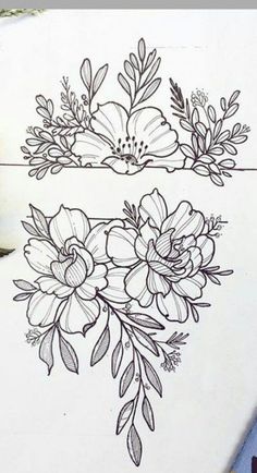 some flowers and leaves are drawn on a piece of paper with pencils next to it