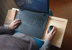 a person sitting at a desk with a laptop and mouse