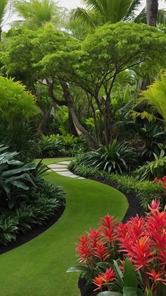 a lush green garden with red flowers and trees