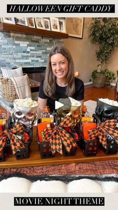 a woman sitting in front of a table filled with halloween treats and candy bags on it