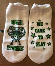 two pairs of white socks with green lettering and stars on the bottom that say, royal game to slay