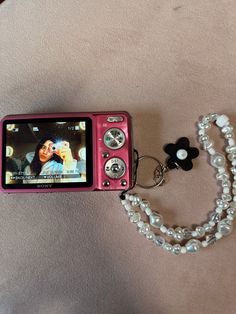 disposable pink canon camera. With a white beaded chain. A black vintage flower chain. Foods For Clear Skin, Aesthetic Objects, School Bag Essentials, All Body Workout, Flower Chain, Summer Scrapbook