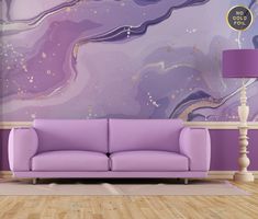 a purple couch sitting in front of a wall with a painting on it's side