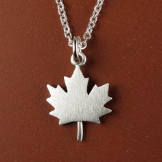 "CHRISTMAS DELIVERY: USA & CANADA:  Delivery before Christmas is not guaranteed. INTERNATIONAL:  It is now too late for delivery before Christmas. This little maple leaf is made of sterling silver.  The pendant is quite TINY, measuring just under 5/8\" (1.5 cm) from top to bottom.  Perfectly simple and a perfect symbol of Canada! The pendant is available alone, or with a sterling silver chain (prices vary depending on length). You can purchase just the pendant/charm, or complete the necklace with a sterling silver box chain.  We also make matching maple leaf earrings:  www.etsy.com/ca/listing/970830486/tiny-maple-leaf-earrings © Stick Man Creations This is our own original design, handcrafted by us, and signed on the back with our logo.   For more information about the creative process, cl Stick Man, Silver Box, Christmas Delivery, Leaf Pendant, Necklace Sterling Silver, Leaf Earrings, Box Chain, Sterling Silver Chain, Creative Process