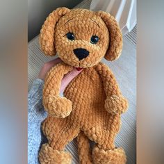 a person holding a brown teddy bear in their hand