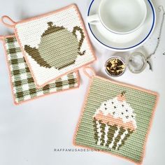 two crocheted coasters with teapot and cup on them next to a plate