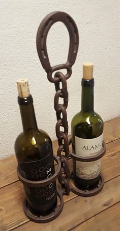 two bottles of wine are chained to each other on a table with a corkscrew