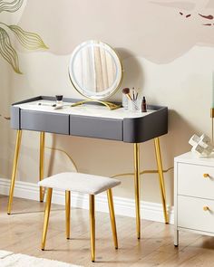 a desk with a mirror, stool and other items on it in front of a wall