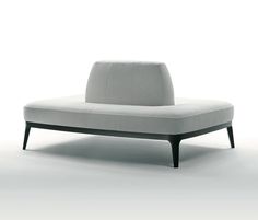 a white couch sitting on top of a floor next to a chair with legs and armrests