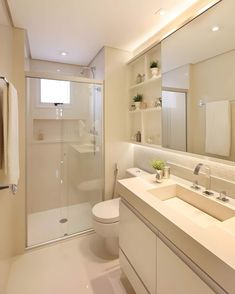 a bathroom with a toilet, sink, and shower in it's own area