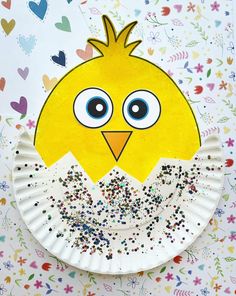 a paper plate with a yellow bird on it and sprinkles all over it