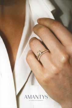 a woman's hand with a diamond ring on her left hand and the words amanys written below it