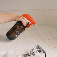 a person is cleaning the floor with a spray bottle and cloth on it's side