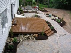 a wooden deck next to a white house