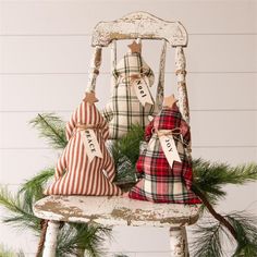 two small christmas trees sitting on top of a wooden chair