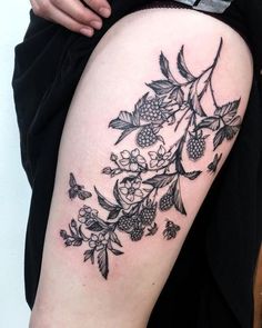 a woman's thigh with flowers and leaves on it