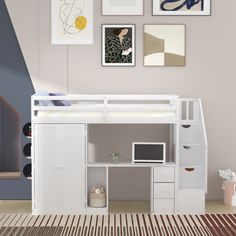 a white loft bed with desk underneath and pictures on the wall above it in a bedroom