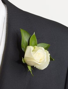 a white rose is placed on the lapel of a black suit