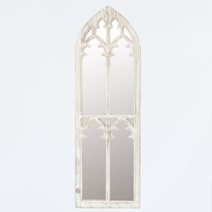 an old white window frame with mirrors on the sides and one in the middle that has been cut out