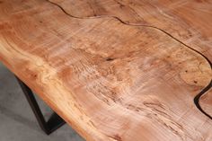 a wooden table with black metal legs and a wood slab on the top that looks like it has been cut in half