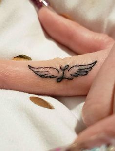 a woman's hand with a small tattoo on it