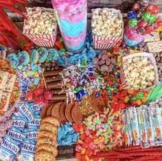 a table filled with lots of different types of candy and treats on it's sides