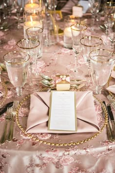 the table is set with silverware and pink napkins