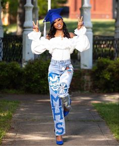 a woman is walking down the sidewalk with her graduation cap on and she has one hand in the air