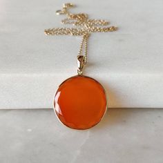 ITEM DESCRIPTION: >> The Pendant is made from Solid 14K Yellow Gold. Gemstone used is absolutely natural and ethically sourced. >> Natural Flat Cut Red Onyx in round shape and bezel setting is studded on it with utmost precision. >> This is a minimalist design and is absolutely hassle-free and everyday jewelry. Gem: Red Onyx Gem size: 20mm Round Gem weight: 9.27 carats Gold purity: 14K (58.33% approx.) Gold weight: 0.59 grams Gross weight: 2.44 grams The Gold purity is guarante Elegant Carnelian Round Pendant Jewelry, Red Polished Round Necklaces, Yellow Gold Carnelian Jewelry With Polished Finish, Elegant Carnelian Jewelry With Large Pendant, Elegant Carnelian Gemstones For Gifts, Elegant Carnelian Gemstones As Gifts, Elegant Carnelian Gemstones As A Gift, Faceted Carnelian Jewelry Gift, Classic Orange Necklace For Gift