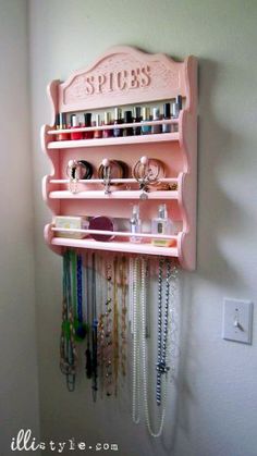 a pink shelf with jewelry hanging from it's sides and the words spicers on it