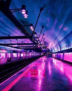 an empty subway station with purple lights