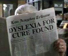 a person holding up a newspaper with the words dyslexa for cure found on it