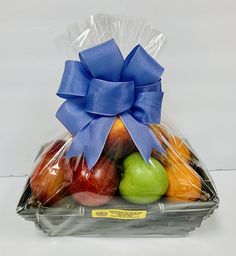 a basket filled with assorted fruit wrapped in cellophane and tied with a blue ribbon