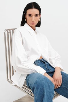 Relaxed and feminine, our oversized Raphaela Shirt is a true dream. Fashioned from crisp European poplin cotton, she's tailored with a sharp collar and a button front, which evens out her floaty shape and dolman sleeves. | Emily, in white, is 5'9.5" (177 cm) tall, wearing size XS. Approximately 29.5" (75 cm), measured from the shoulder to the bottom hem. Sleeve length approximately 22.5" (57.5 cm).100% European Poplin Cotton. Machine wash on delicate cycle or hand wash in cold water. Tumble dry White Relaxed Fit Poplin Shirt, Classic Oversized Poplin Blouse, Oversized Classic Poplin Blouse, Classic Oversized Cotton Blouse, Oversized Classic Cotton Blouse, Oversized Poplin Tops For Spring, White Oversized Poplin Shirt, Oversized White Poplin Shirt, Oversized Collared Poplin Top