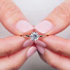 a woman's hands holding a diamond ring