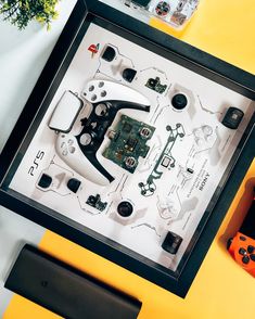 a table with some electronics on it and a game controller in front of the frame