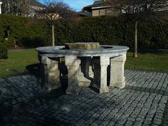 a stone table sitting on top of a brick walkway