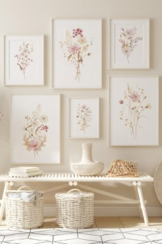 a white bench sitting in front of a wall with pictures on it and wicker baskets