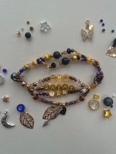 several bracelets with charms on them sitting on top of a white table next to each other