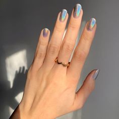 a woman's hand with hologish manicures and a gold ring