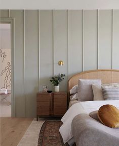 a bed sitting in a bedroom next to a wooden dresser and lamp on top of a rug