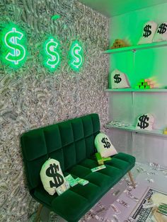 a green couch sitting in front of a wall with dollar signs and neon lights on it