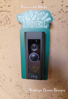 a ring video camera mounted to the side of a wall in front of a sign