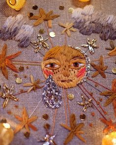 a close up of an embroidered cloth with stars and other decorations on top of it