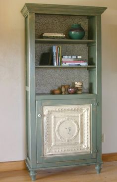 a green bookcase with books on top of it