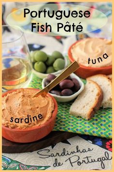 a table topped with bread and olives next to bowls of fish pate on top of a cloth