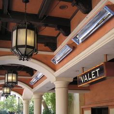 the inside of a building with columns and lights hanging from it's ceilings