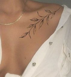 a woman with a flower tattoo on her chest and shoulder, wearing a white shirt