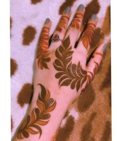 a woman's hand with henna tattoos on it