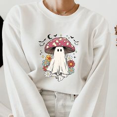 Retro Halloween Sweatshirt, Funny Halloween Ghost Sweatshirt, Halloween Hiking Sweatshirt, Spooky Season Sweatshirt Hello there!  Welcome to SoftQualityShirtstore.  Here, you will discover a wide selection of affordable, high-quality personalized designs and unique creations that are comfortable, stylish, and perfect for your family, friends, and loved ones. Our prints are created using the latest technological materials, and each order is meticulously prepared from the production process to the Novelty White Tops For Fall, White Graphic Print Sweatshirt For Halloween, Fall Mushroom Print Crew Neck Sweatshirt, Fall Mushroom Design Crew Neck T-shirt, Fall Crew Neck T-shirt With Mushroom Design, White Sweatshirt With Character Print For Fall, White Cartoon Print Sweatshirt For Fall, Fall Crew Neck T-shirt With Mushroom Print, Halloween Sweatshirt With Cartoon Print And Crew Neck